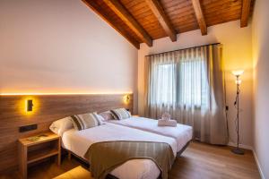a bedroom with a large bed and a window at Casas Green Ordesa in Aínsa +103 photos