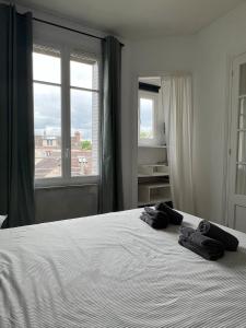 a bedroom with a white bed with two towels on it at Le Clair Bellifontain in Fontainebleau