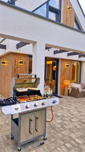 a patio with a grill with a pizza on it at Bosarosa Forest & Lake Villa z jacuzzi wanna SPA in Laski Małe