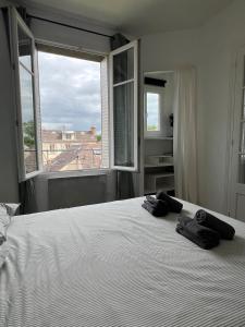 a bedroom with a large bed with two towels on it at Le Clair Bellifontain in Fontainebleau +17 photos