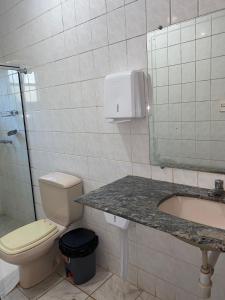 a bathroom with a toilet and a sink and a mirror at Pousada Sant`Ana in Sabará +35 photos
