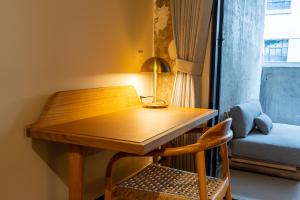a desk with a lamp and a chair in a room at Sela V Hotel in Brooklyn
