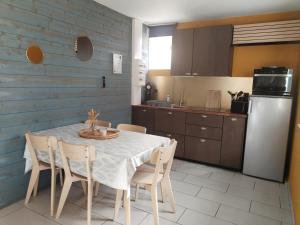 a kitchen with a table and chairs and a refrigerator at Hédoniste 1 in Herpy-lʼArlésienne