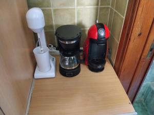 a red and black coffee maker sitting on a counter at The cave of Cyclops in Makri