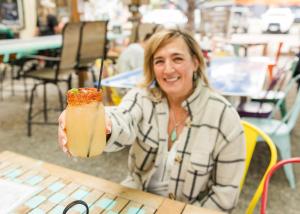 a woman sitting at a table holding a drink at The Trail Head in South Fork +13 photos