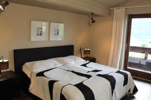 a bedroom with a bed with a black and white comforter at Dorfchalet in Goldegg