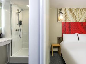 a hotel room with a bed and a shower at ibis Plymouth in Plymouth +90 photos
