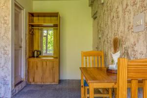 a dining room with a wooden table and a window at La Heim Hostels in Manāli