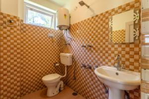 a bathroom with a toilet and a sink at La Heim Hostels in Manāli