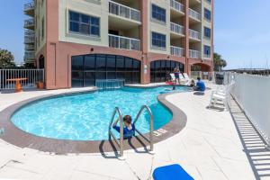 a child is playing in a swimming pool at a hotel at Harbour Place 510 in Gulf Shores