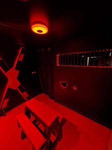 a red room with a table and a chair at Love room location de 15h a 17h in Wattignies +4 photos