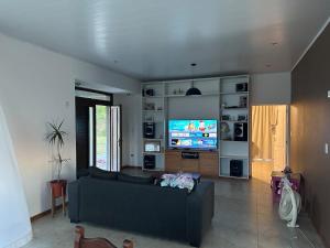 a living room with a couch and a flat screen tv at Quinta Narbaiz in Estación Nueve de Julio Sur