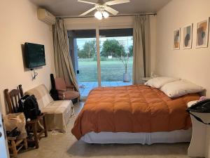 a bedroom with a bed and a couch and a window at Quinta Narbaiz in Estación Nueve de Julio Sur