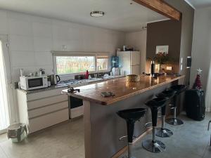 a kitchen with a counter and some stools in it at Quinta Narbaiz in Estación Nueve de Julio Sur