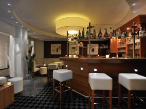 a restaurant with a bar with white stools at Mercure Hotel Lüdenscheid in Lüdenscheid