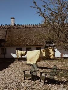 two chairs in front of a house with a clothes line at Axatorpsgården in Trelleborg