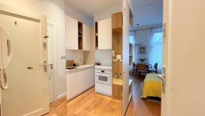 a kitchen with white cabinets and a dining room at Ruzop Apartament - Modern studio in center, self check-in, WiFi in Poznań