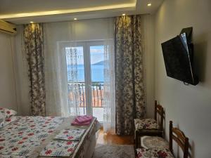 a bedroom with a window with a view of the ocean at Rooms Vlaovic in Herceg-Novi