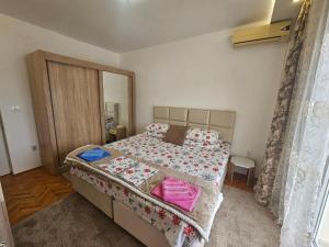 a bedroom with a large bed with pink pillows at Rooms Vlaovic in Herceg-Novi