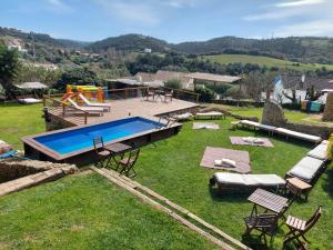 a backyard with a swimming pool and a playground at Terra Lodge in Ericeira