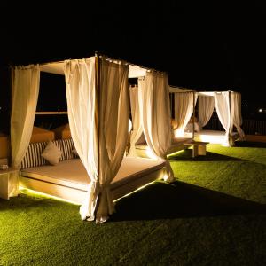 a canopy bed with curtains and lights on the grass at Yin Hotel & Spa in Marrakesh +219 photos