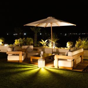 a patio with a table and an umbrella at night at Yin Hotel & Spa in Marrakesh