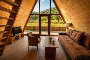 a living room with a couch and a table at Wooden Cabin 1 with Pool Access - Bate Bole Resort in Ohrid