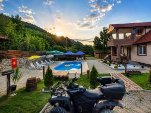 a motorcycle parked in front of a house with a pool at Wooden Cabin 1 with Pool Access - Bate Bole Resort in Ohrid