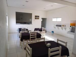 a room with tables and chairs and a kitchen at Hotel Imperador in Jaraguá