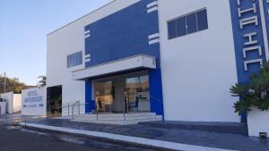 a blue and white building with some chairs in it at Hotel Imperador in Jaraguá