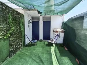 a room with a green lawn and two chairs at Sunset In Malabrigo in Puerto Chicama