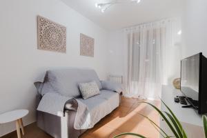 a living room with a couch and a tv at Siente Cazorla Alojamientos in Cazorla