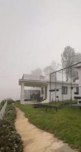 a building with a dirt road in front of it at The White Haven Kotagiri in Kotagiri
