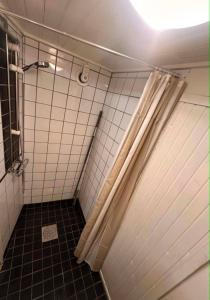 a bathroom with a shower with a shower curtain at Daltorps skola, Övernattningsstuga H, Self check in, Übernachtungskabine H in Skövde