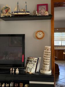 a shelf with a clock and a book on a table at Casa Shpresë - The Traditional Suite in Tirana