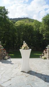a white vase with flowers in it on a stone ground at Landsitz Kammerburg - Villa in Lorch am Rhein +4 photos