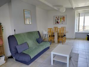 a living room with a couch and a table at Duplex sur la Baie in Saint-Benoît-des-Ondes