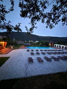 a pool with a bunch of chairs and a group ofitures at Guculka Apartments in Yaremche