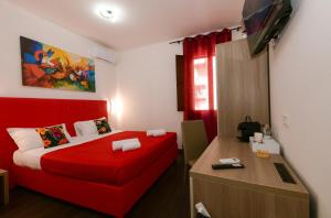 a bedroom with a red bed and a desk at 100 Passi dal Porto in Civitavecchia
