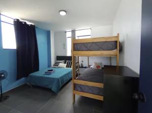 a bedroom with two bunk beds and a couch at Sunset In Malabrigo in Puerto Chicama