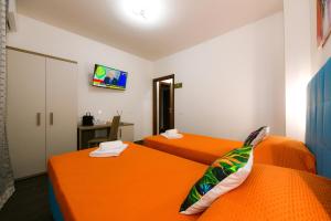 two beds in a room with orange beds at 100 Passi dal Porto in Civitavecchia +42 photos