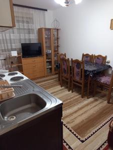 a kitchen with a sink and a table and chairs at Apartman Markovic in Vranje +3 photos