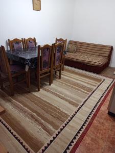 a dining room with a table and chairs and a couch at Apartman Markovic in Vranje