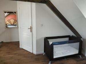 a room with a white wall and a door at Duplex sur la Baie in Saint-Benoît-des-Ondes