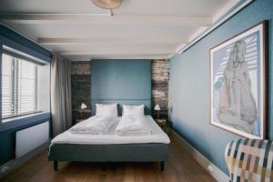 ein Schlafzimmer mit einem Bett in einem blauen Zimmer in der Unterkunft Gamlekaien in Skudeneshavn