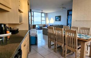 a kitchen and dining room with a table and chairs at Scottburgh Views 707 Seafront Apartment in Scottburgh