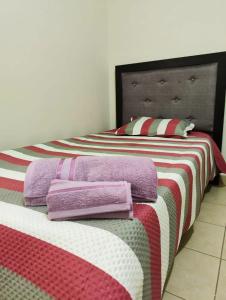 a bedroom with two beds with purple and pink blankets at Valle Dorado Residence in Colcapirhua
