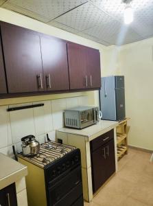 a kitchen with a stove and a microwave at Valle Dorado Residence in Colcapirhua