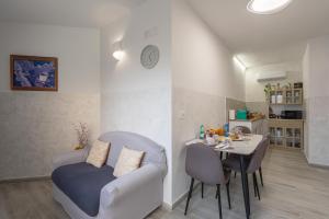 a living room with a table and a couch at L'Aurora Porto Torres in Porto Torres