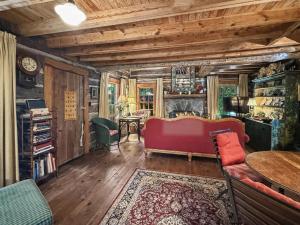 a living room with a red couch and a table at Melrose Cabin in Highlands